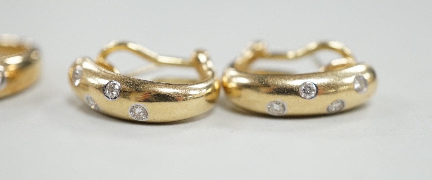 A modern 14k and gypsy set six stone diamond band, size N and a pair of matching earrings, gross weight 8.1 grams.